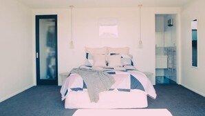 A bedroom with a bed, bedside tables, a door, and a mirror. - Relax In True New Modern Style (Christchurch)