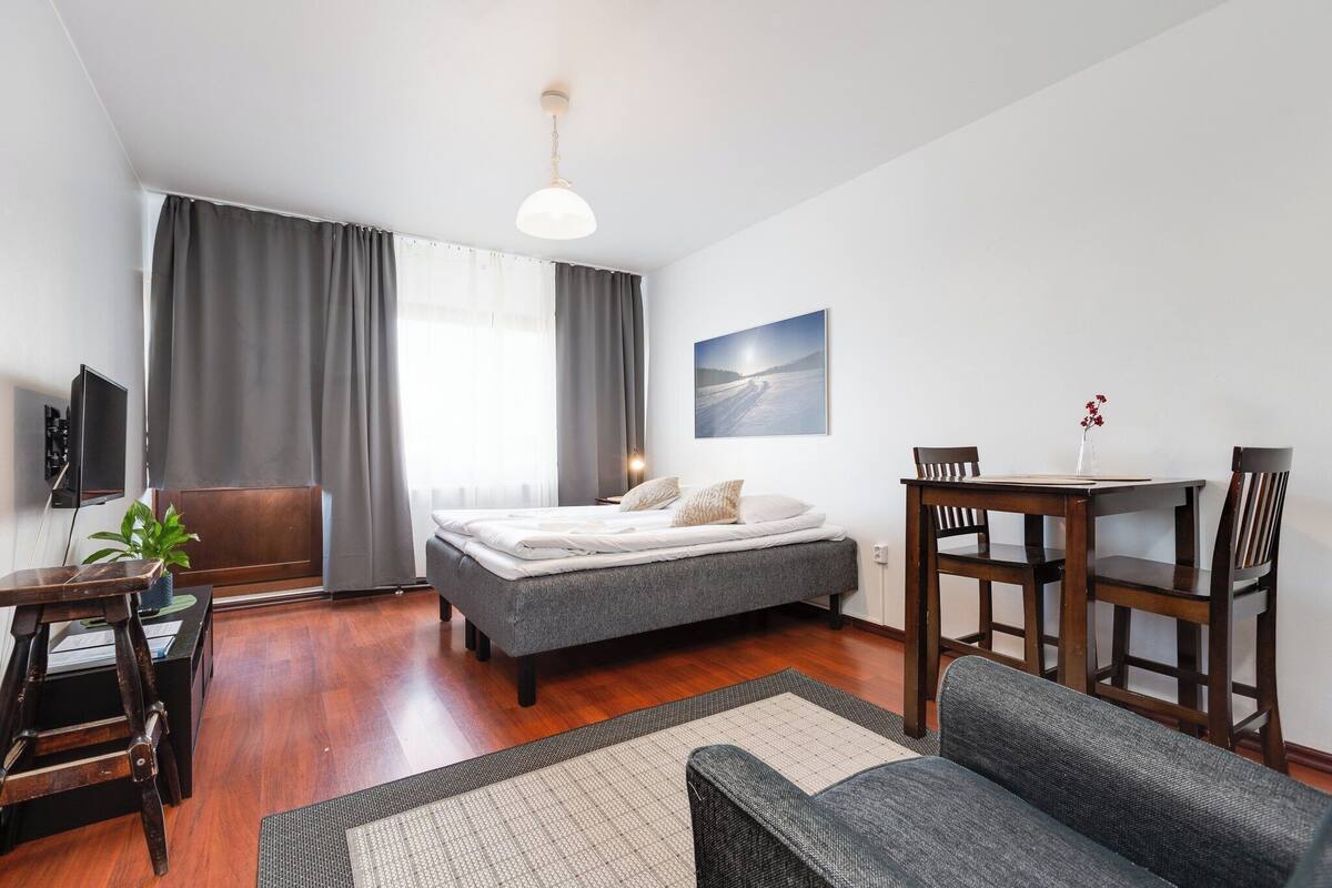 Ein modernes Schlafzimmer mit einem Bett, einem Schreibtisch, einem Stuhl und einem Esstisch.