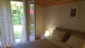 A bedroom with a bed, a nightstand, a lamp, and a window with curtains. - House between Lake and Ocean (Lacanau)