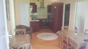 A compact living space with a dining area, kitchen, and a small seating area. - House between Lake and Ocean (Lacanau)