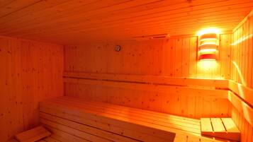 Un sauna avec des bancs en bois et un luminaire fixé au mur.