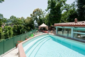 A swimming pool with a green fence, lounge chairs, and a gazebo. - Albergo Argentina SRL (Fiuggi)