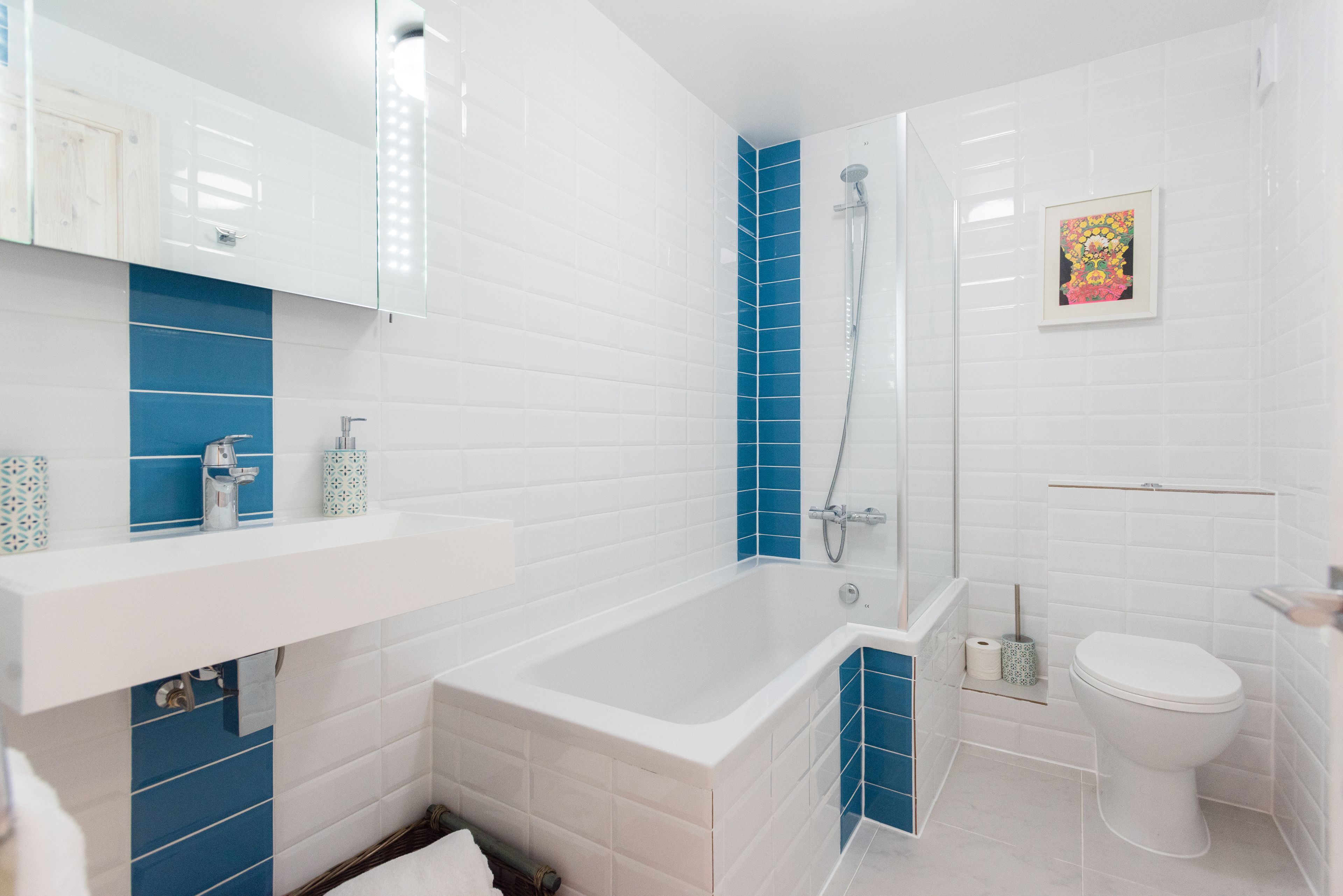 A bathroom with a white bathtub, a shower, and a toilet.