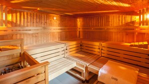 Un sauna avec des bancs en bois et un banc sur lequel est posée une serviette portant l’inscription « SAUNA ».