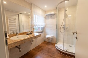 Tweepersoonskamer | Badkamer | Een douche, een haardroger, handdoeken, zeep