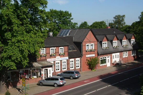 A traditional brick building with a red roof, multiple windows, and a sign indicating it is a restaurant. - Hotel Gasthof Gose (Rochau)