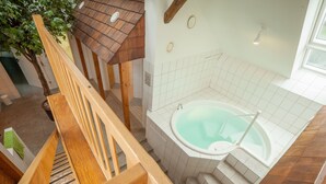 Une salle de bain moderne avec un escalier en bois, une baignoire et un mur carrelé.