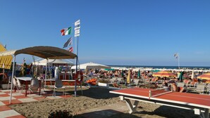 A beachside area with tables and chairs, flags, and a clear view of the sea. - Hotel Residenza Giardino (Bellaria-Igea Marina)
