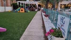A pathway with 'HRG' painted on the ground, leading to a building with a sign 'HRG CUCINA ROMAGNOLA PIZZERIA'. - Hotel Residenza Giardino (Bellaria-Igea Marina)