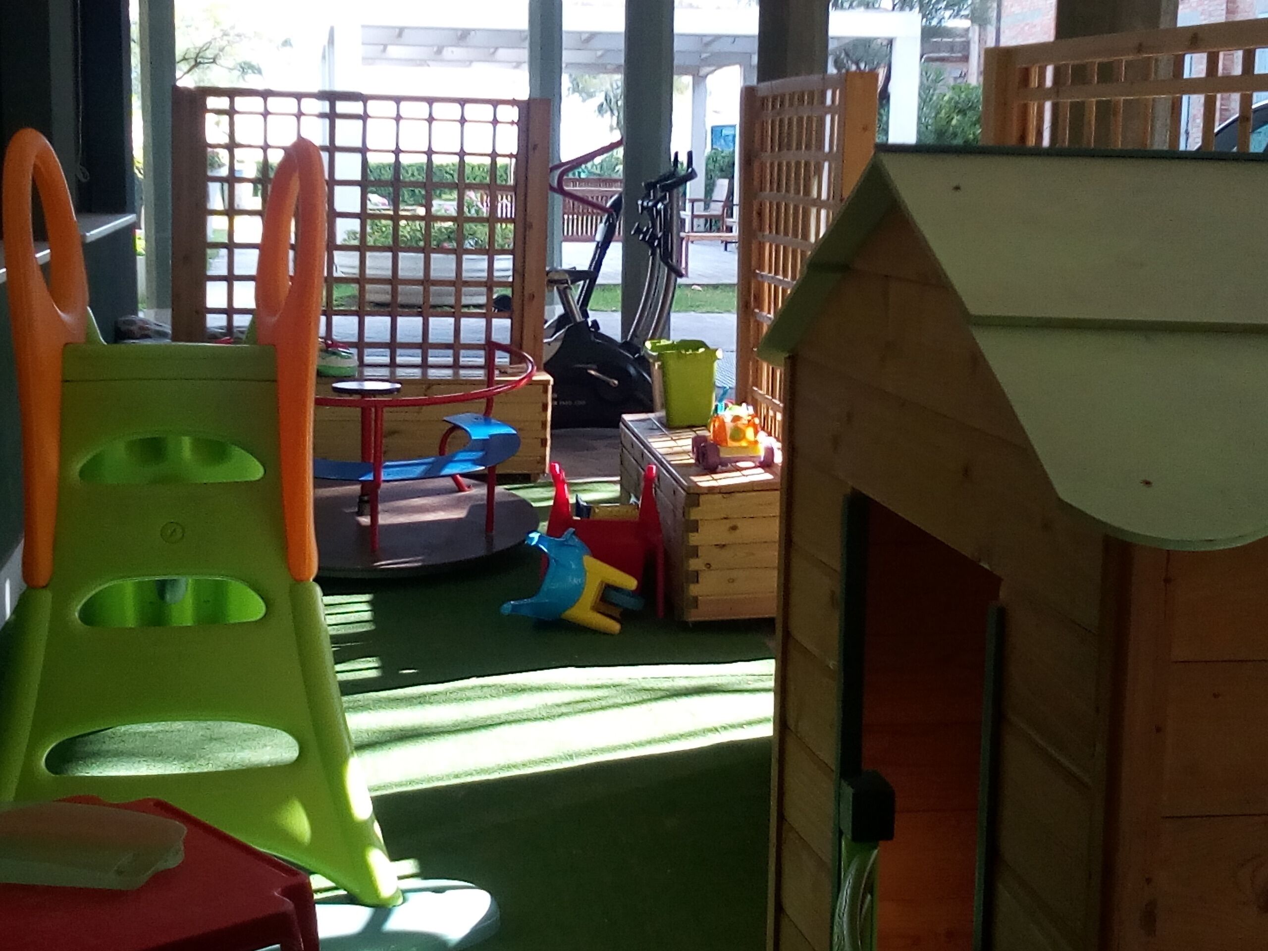 A children's play area with a slide, climbing structures, and a small playhouse.