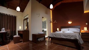 A bedroom with a large bed, a wooden dresser, a nightstand, and a mirror. - Casa San Vicente Yucay (Yucay)