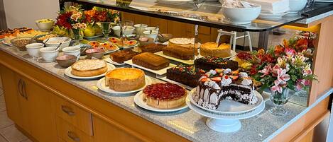 A buffet with various desserts and fruits.