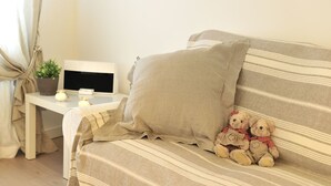 Un sofá a rayas con un cojín beige y dos osos de peluche.