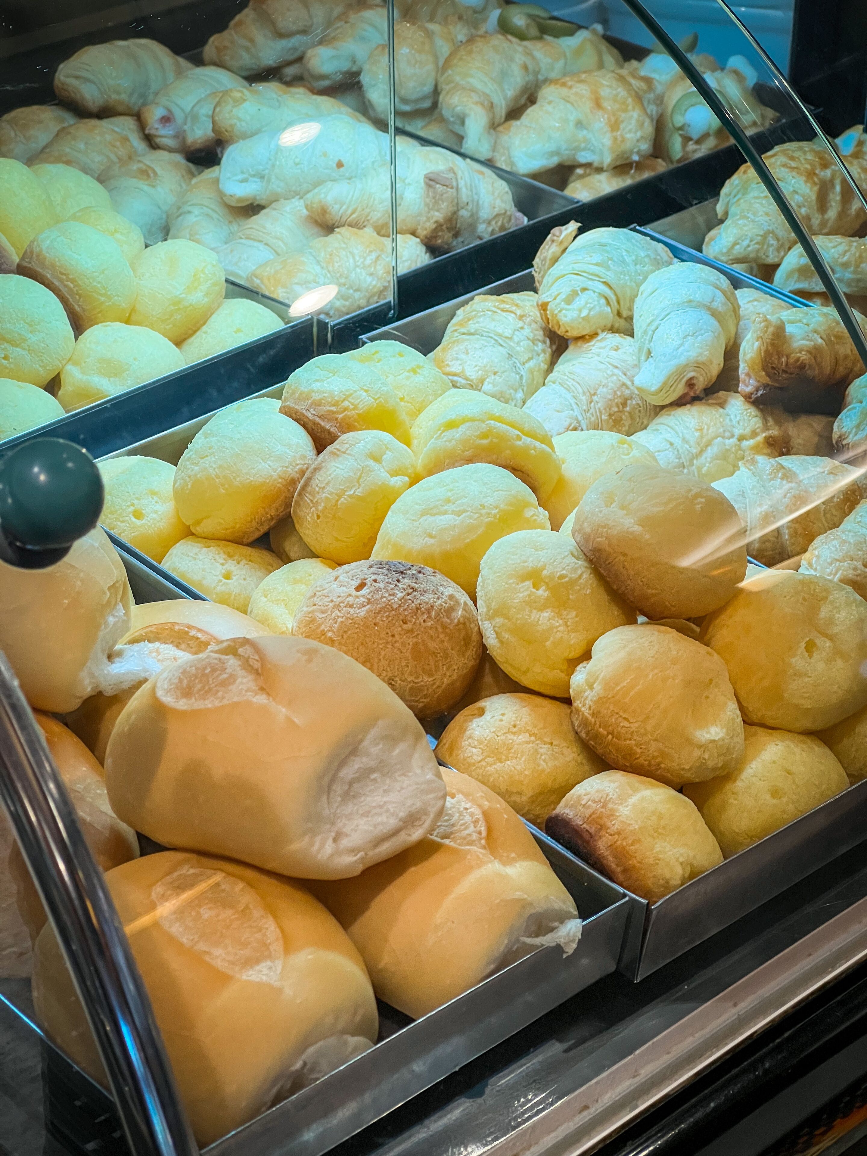 Une vitrine de boulangerie remplie de différents types de pains et de pâtisseries.