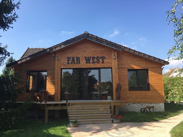 Um edifício de madeira com uma placa que diz 'FAR WEST'.