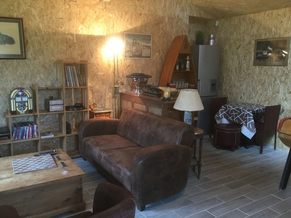 A cozy living room with a brown sofa, wooden coffee table, and a bookshelf.