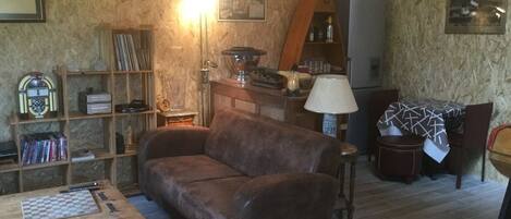 A cozy living room with a brown sofa, wooden coffee table, and a bookshelf.
