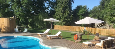 Una piscina al aire libre de temporada, tumbonas