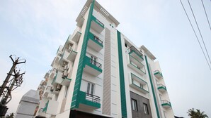A multi-story residential building with balconies, a gated entrance, and a modern architectural design. - Capital O 14043 Hotel Star Holiday (Chennai)