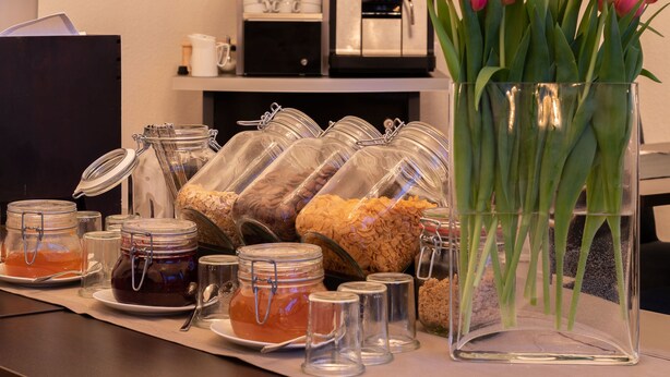 A breakfast buffet with various food items and a vase of tulips. - Hotel Villa von Sayn (Rheinbreitbach)
