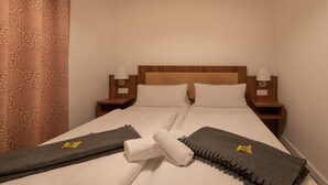 A neatly made bed with white linens, two pillows, and two nightstands with lamps. - Hotel Villa von Sayn (Rheinbreitbach)