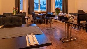 A hotel room with a dining area, large windows, a chandelier, and a piano. - Hotel Villa von Sayn (Rheinbreitbach)