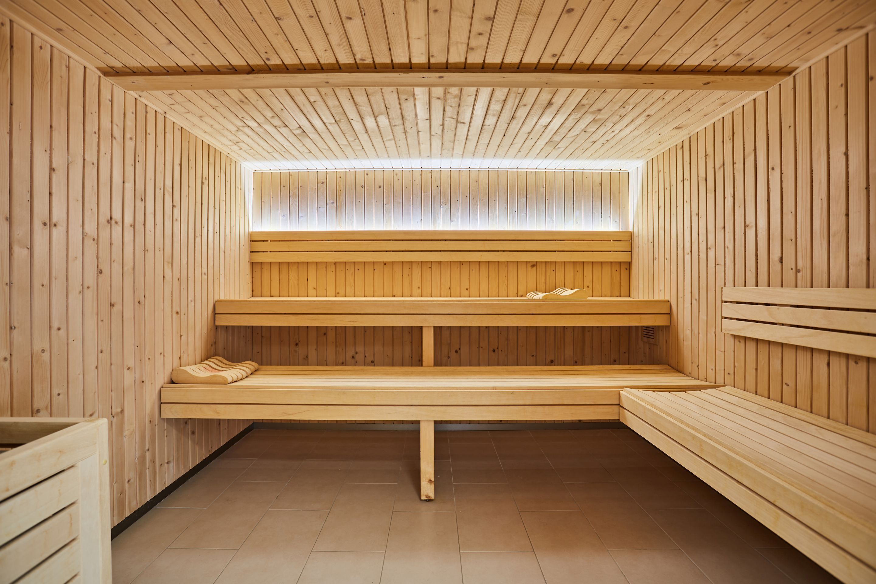 A sauna with wooden benches and a sloped ceiling.