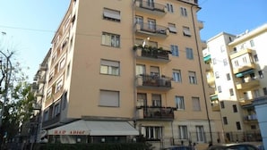 A multi-story building with balconies, a visible bar named "BAR ADIGE" at the ground level, and a clear sky. - Terrazze Italiane City Center (Verona)