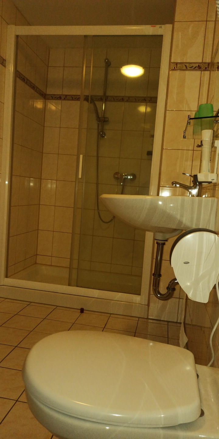 A bathroom with a shower, sink, and toilet.