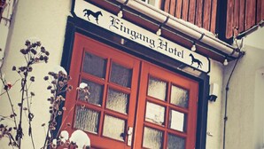 Un bâtiment avec une porte rouge et une enseigne au-dessus indiquant « Hôtel Fingang ».