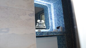L’intérieur d’un hôtel avec un mur recouvert de carreaux bleus et une enseigne indiquant « Schwarzes Ross Hotel & Restaurant ».