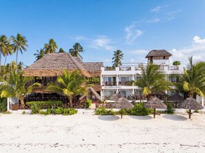 A beachfront hotel with a thatched-roof structure, a balcony, and a sign reading 'ISLA BONITA HOTEL'. - Isla Bonita Zanzibar Beach Resort (Matemwe)