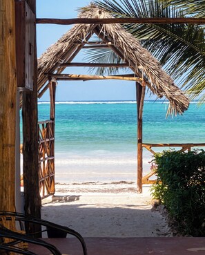 A beach view with a wooden structure and a thatched roof. - Isla Bonita Zanzibar Beach Resort (Matemwe)