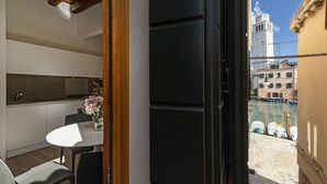 Een moderne keuken met witte kasten en een eethoek met een tafel en stoelen.