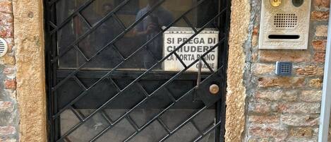 A brick building with a numbered door (6242) and a sign indicating a service for cleaning and maintenance.