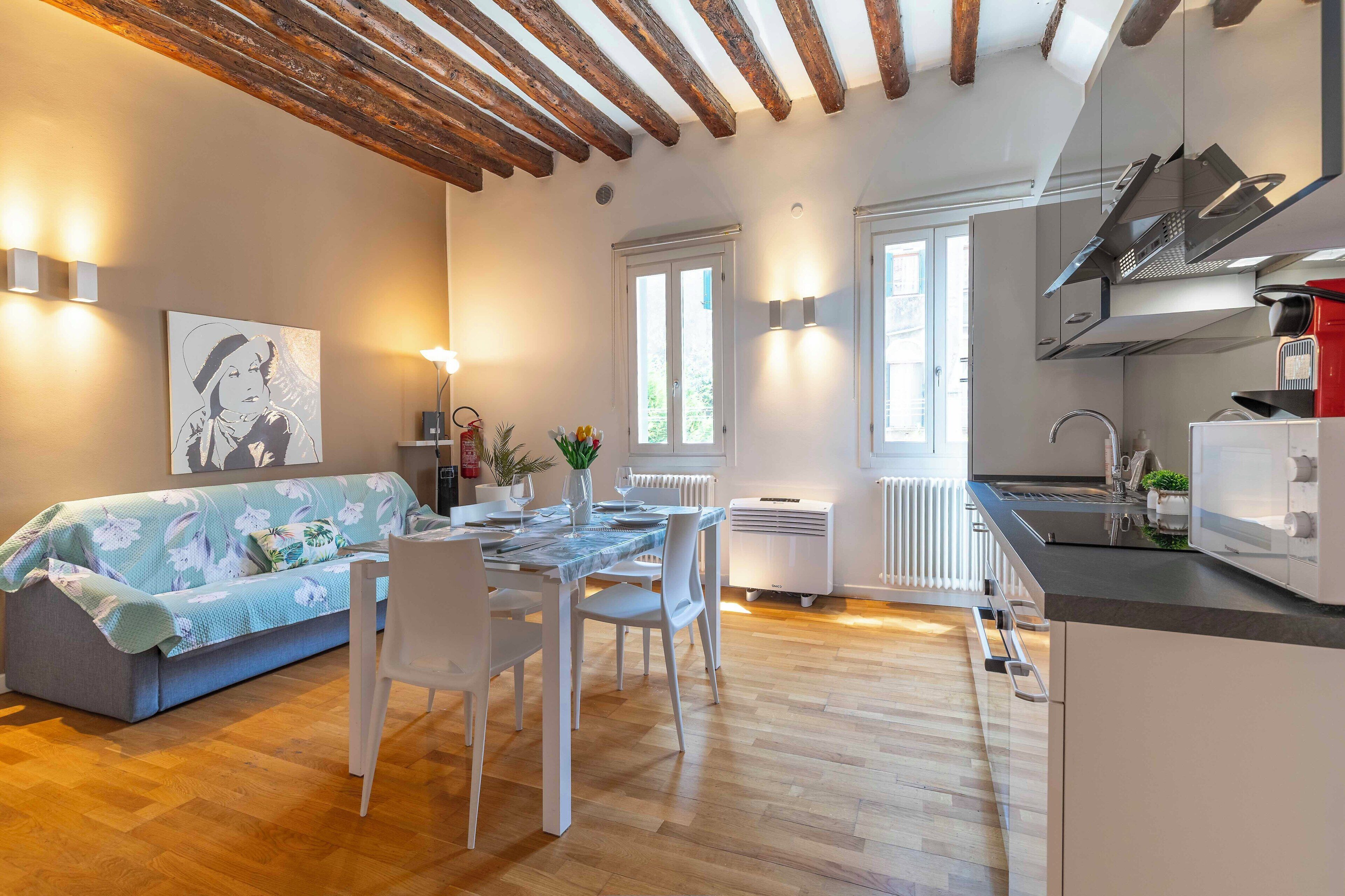 A modern kitchen with a built-in oven and a dining area with a table set for two.