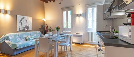 A modern kitchen with a built-in oven and a dining area with a table set for two.