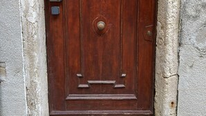 Una puerta de madera con una placa numérica encima.