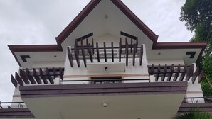 A two-story building with a balcony, a sign reading "Country El Vino," and surrounding greenery. - Bayview Country Inn El Nido (El Nido)