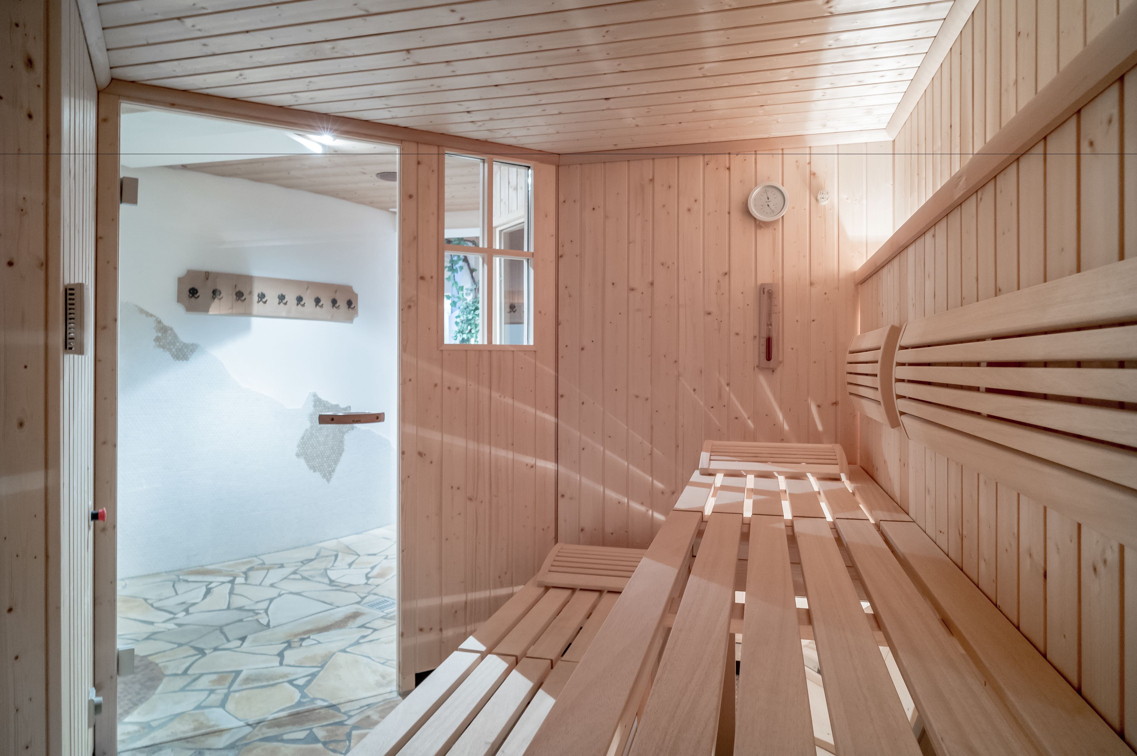 A sauna room with wooden benches and a stone floor.