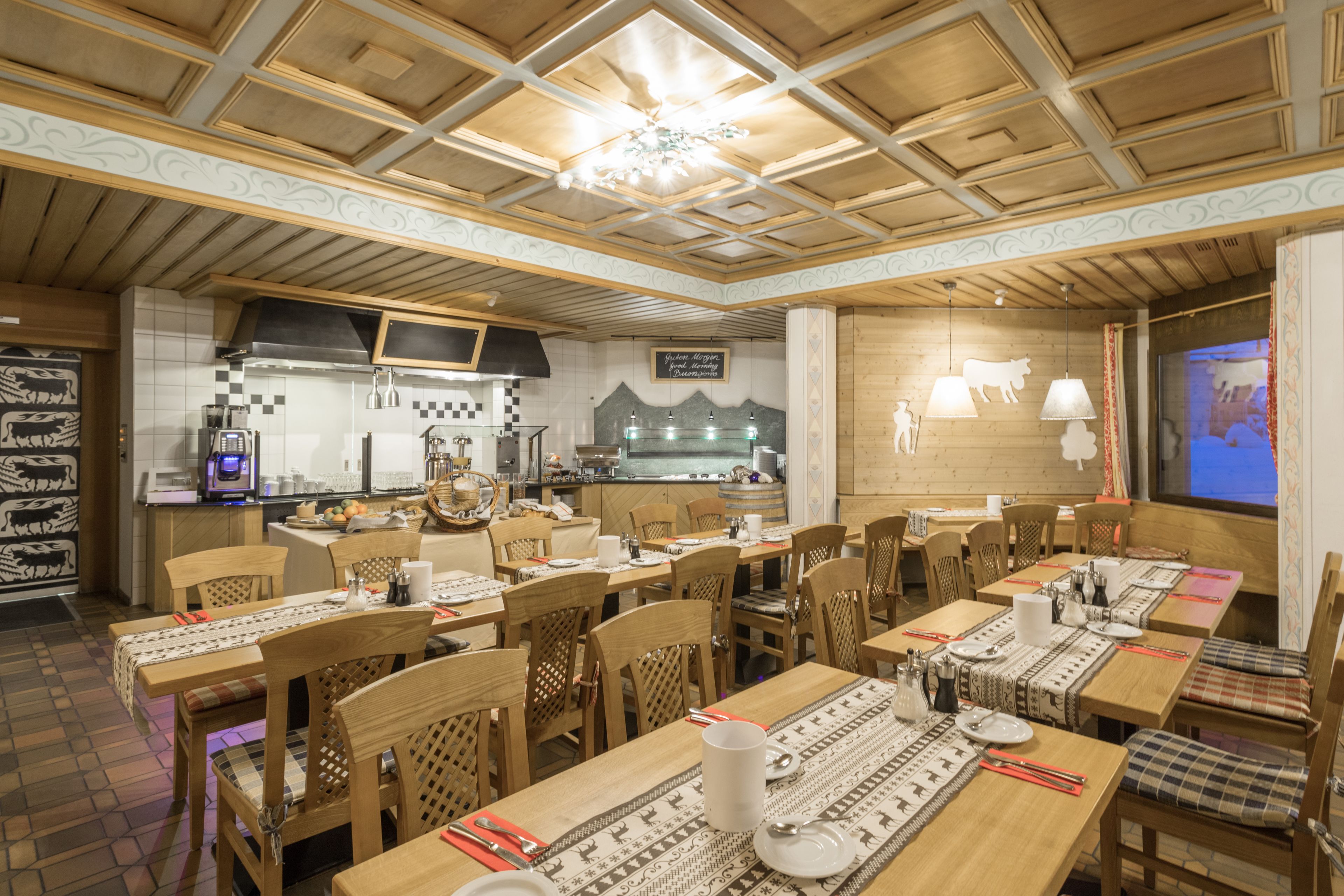 Ein Restaurant mit Holzkubaturen, einer Küchenzeile und einer projizierten Leinwand an der Wand.