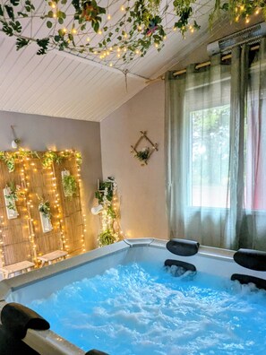 Un espace détente avec un jacuzzi, des éléments de décoration murale en bois et une fenêtre avec des rideaux.