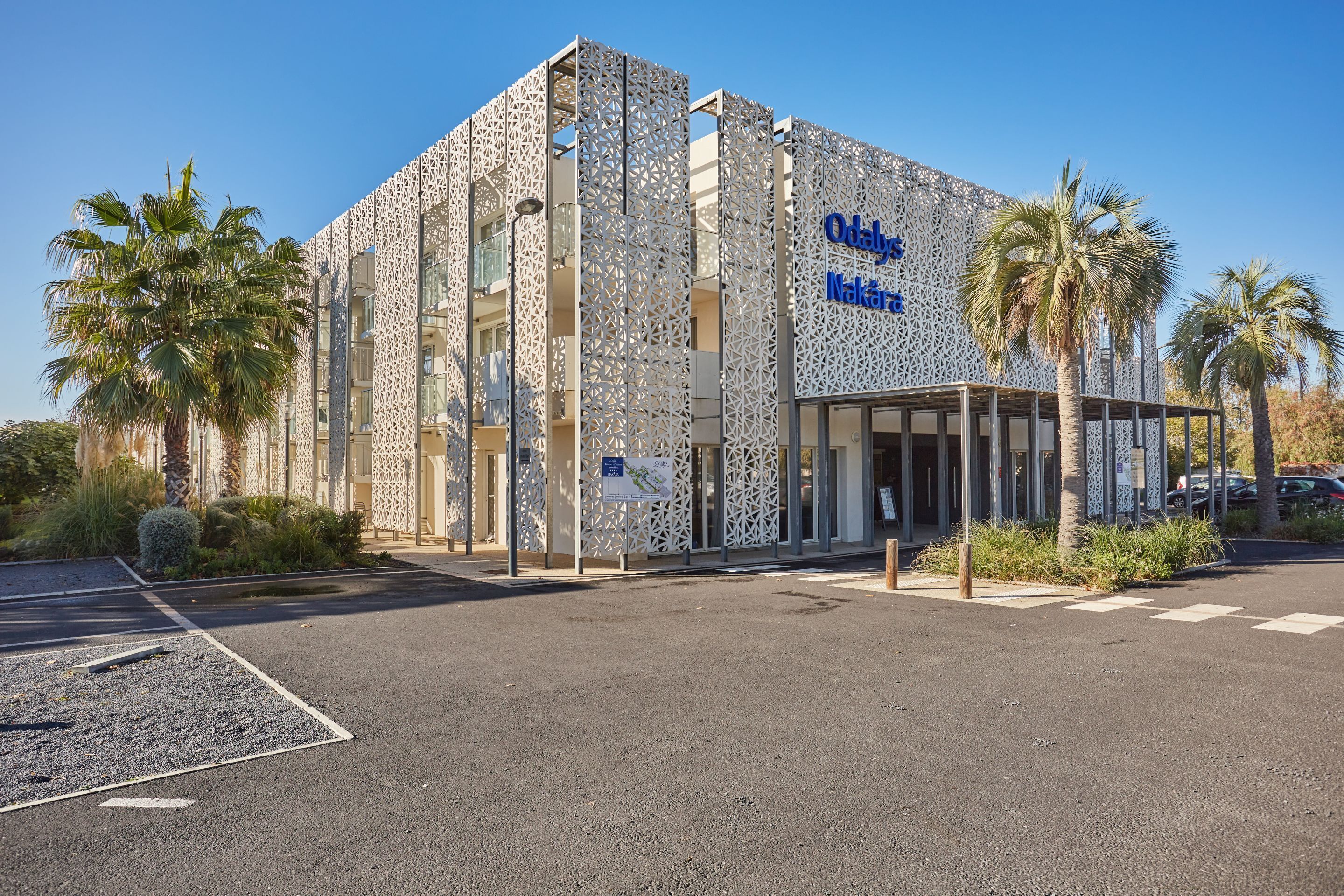A building with a distinctive geometric facade and a sign reading "Odaly Nakara."