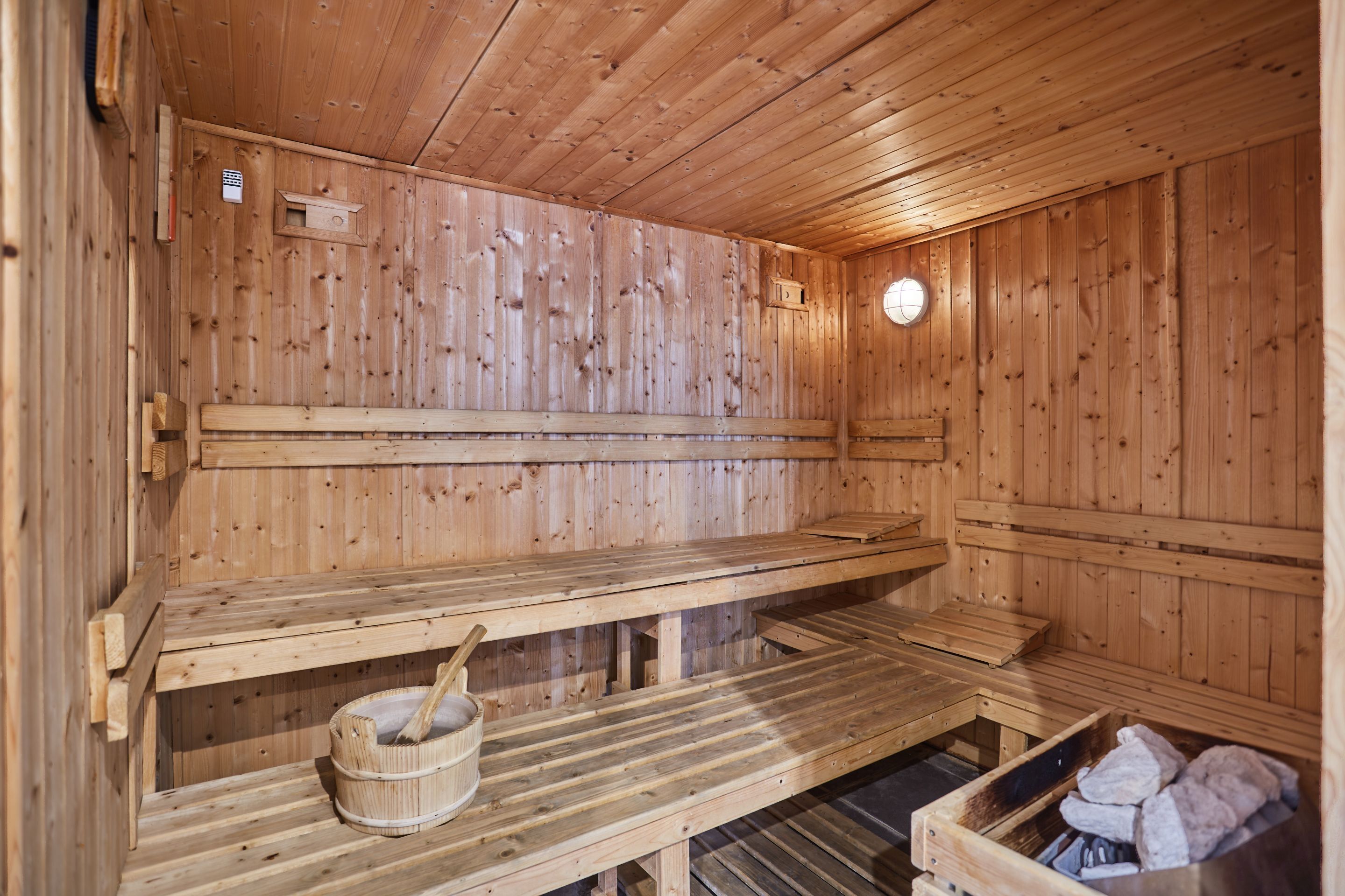 Un sauna en bois, avec des bancs et un seau.