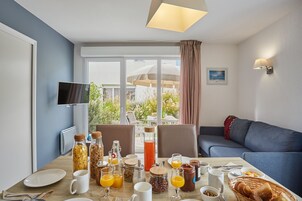 Una mesa con alimentos para el desayuno y vistas al exterior.