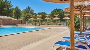 A swimming pool with lounge chairs and thatched umbrellas. - Résidence Odalys Shangri-La - Les Hauts de Cassis (Carnoux-en-Provence)