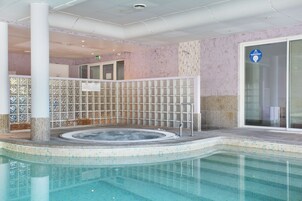 Una piscina cubierta, una piscina al aire libre de temporada, tumbonas
