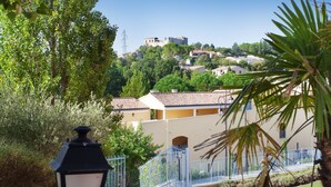 A residential area with houses on a hillside, a lamp post, and a blue fence.