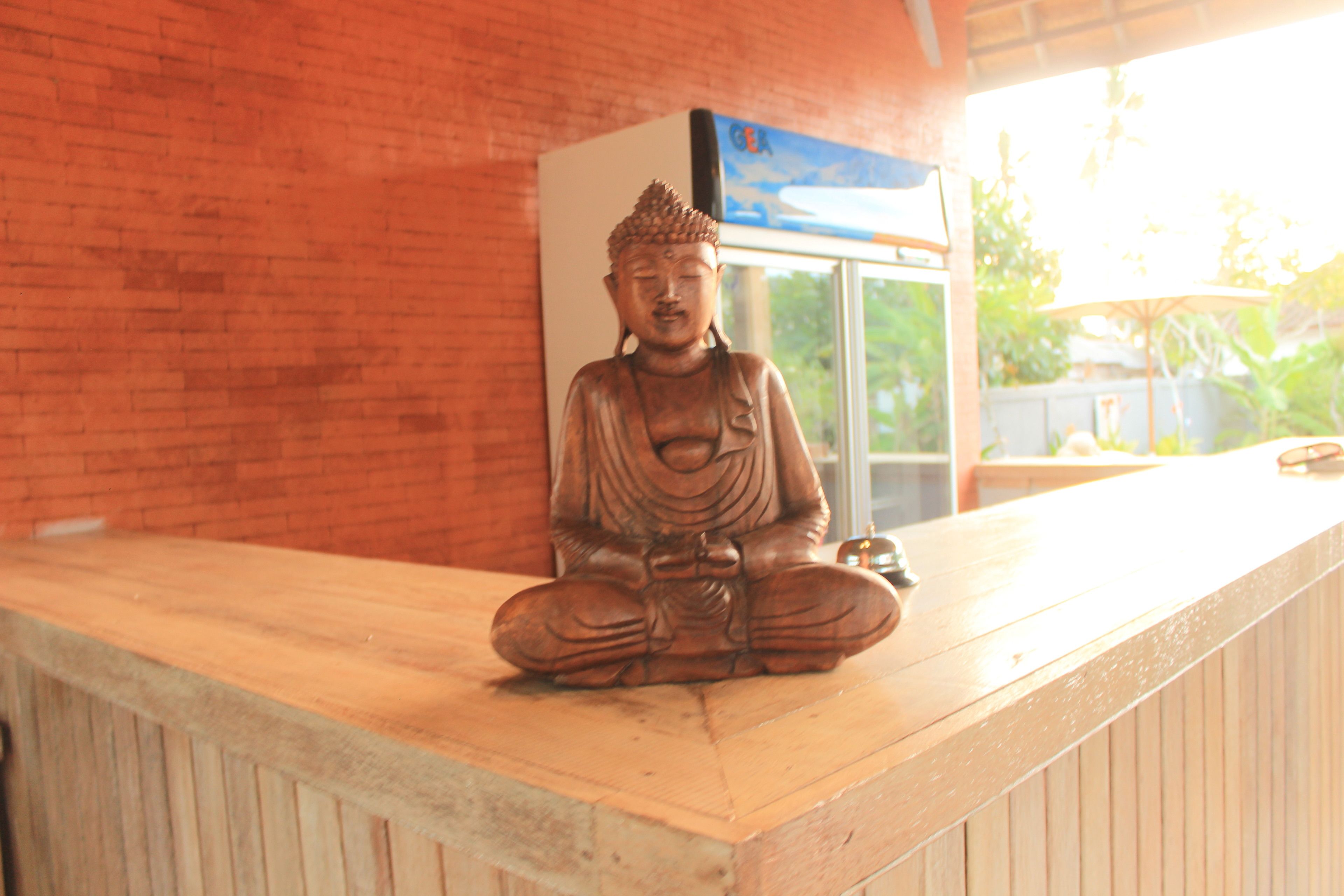 A wooden statue of a seated figure on a counter.