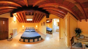 A bedroom with a large bed, wooden beams, a radiator, and a small table with a plant. - Locanda Modigliani (Ferrara)